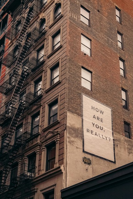 A sign on a building that says, "How Are You, Really?"