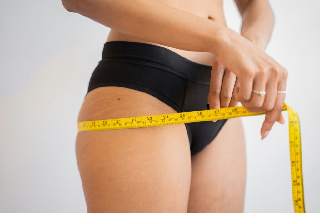 A woman measuring the width of her hips - not an uncommon occurrence for someone with body dysphoria 